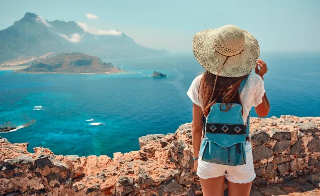sunny seaside view with woman in woven hat 